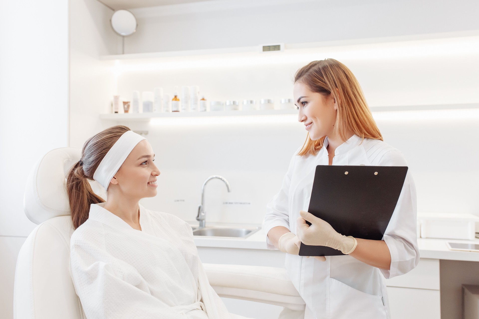 Young pretty woman came to a beauty salon and consults with a doctor