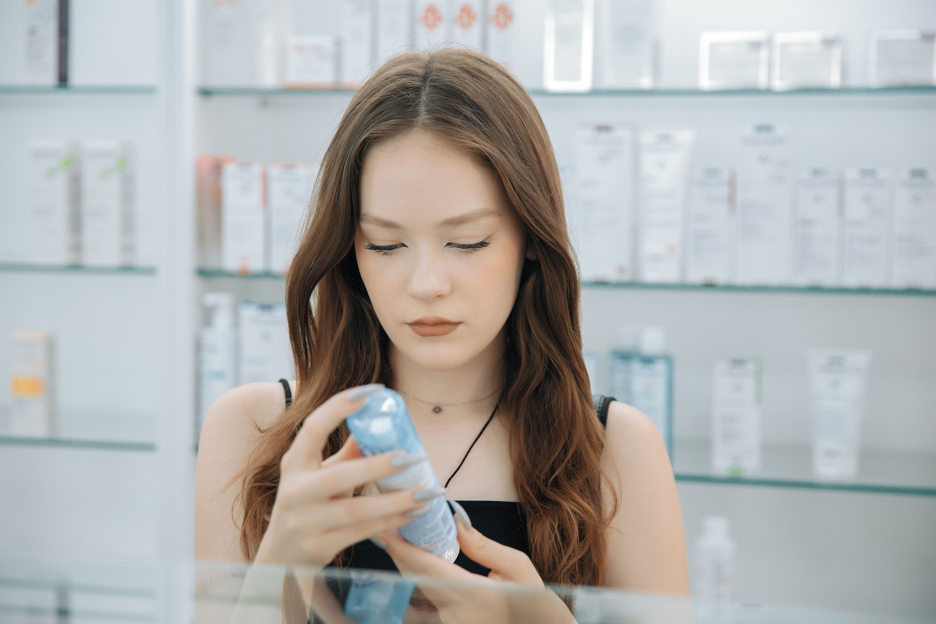 Young woman choosing cosmetics in a pharmacy or beauty store